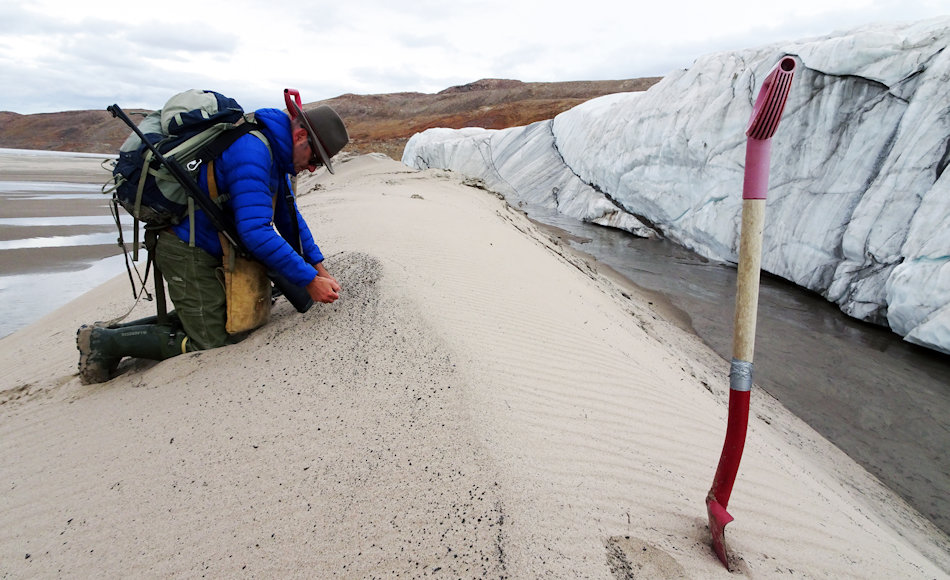 Kurt Kjær nimmt Sandproben and er Front des Hiawatha Gletschers. Der Gletscherfluss transportierte diesen Sand vom Grund des Einschlagkraters zur Eiskante. Bild: Svend Funder